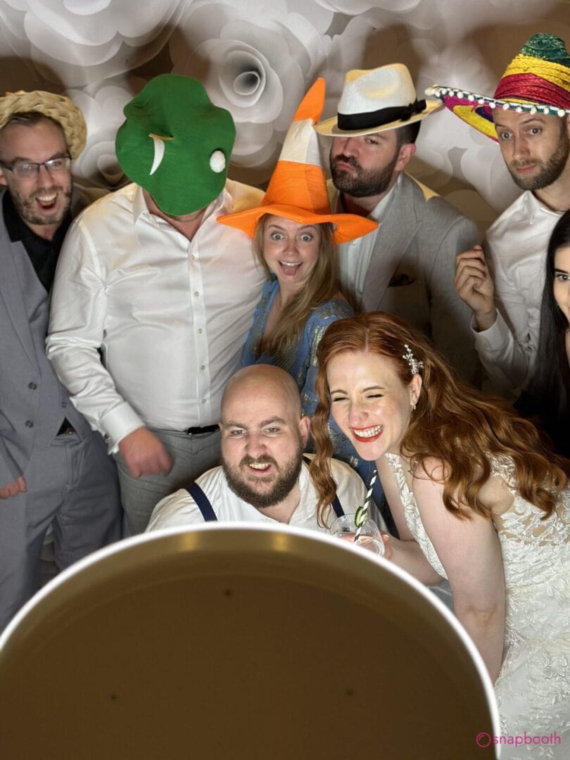 A group of people in a photo booth with hats. Photo Booth Hire Chalfont St Giles