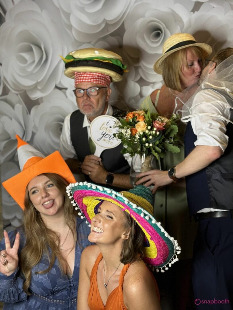 Wedding guests laughing with fun props in a Snap Booth photo booth in High Wycombe