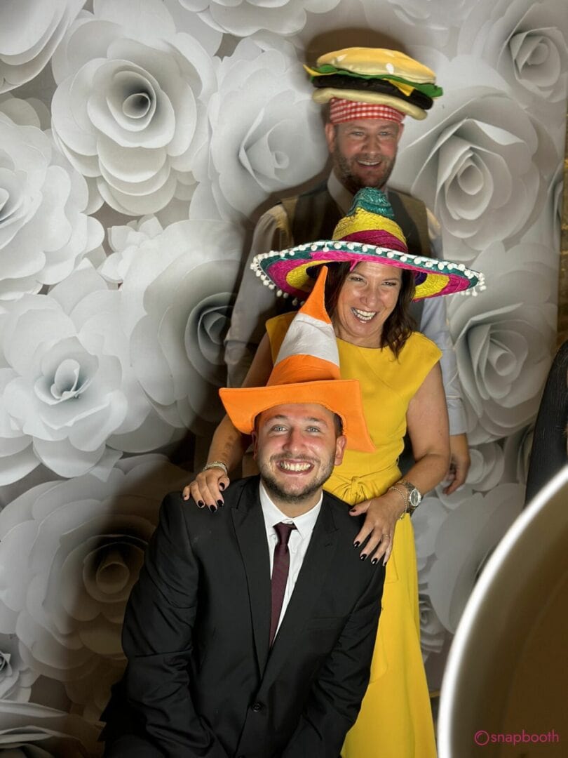 man in a suit with blue eyes using the selfie pod with his parents. Having a great time