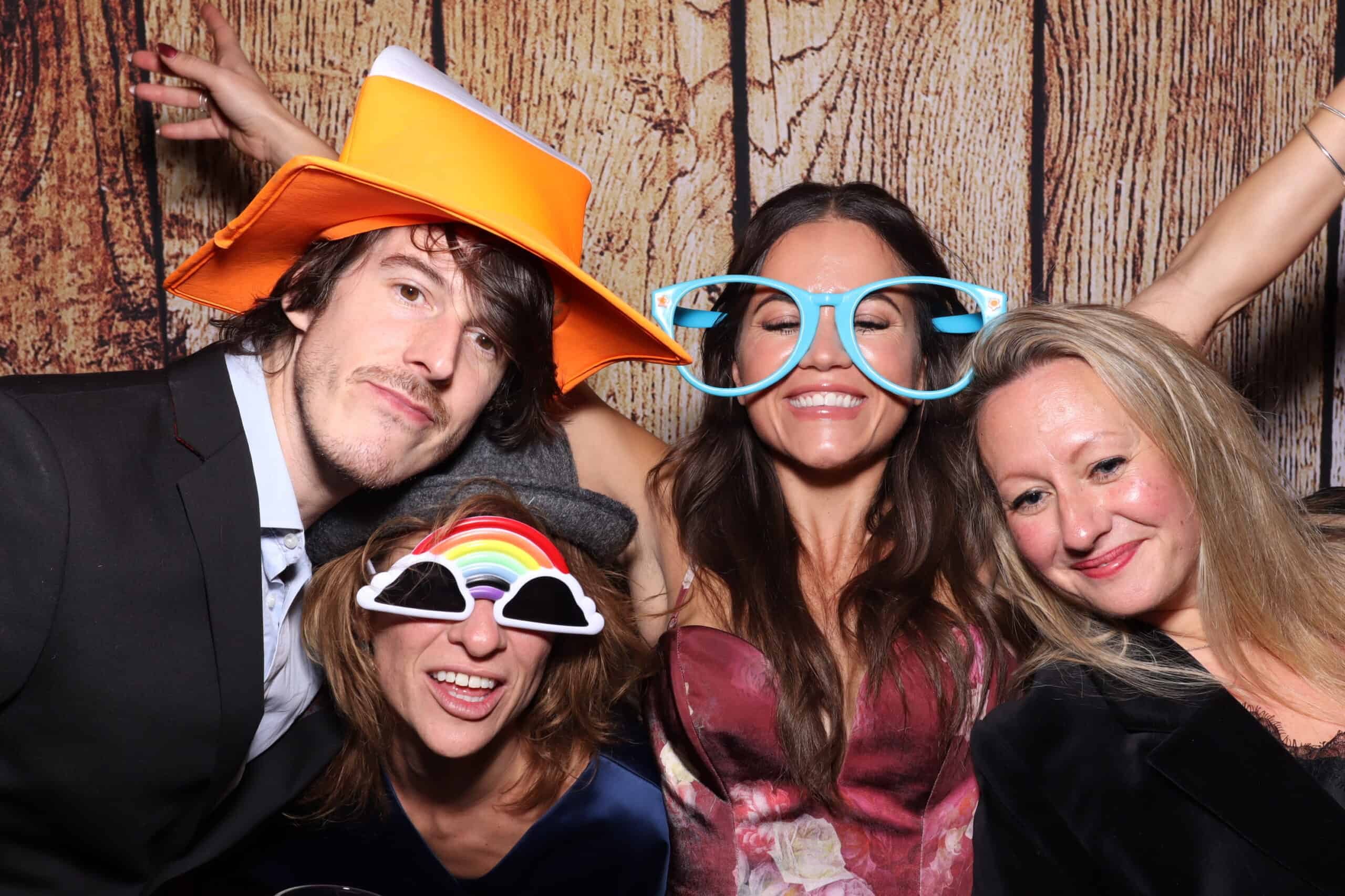 Photo booth hire guests with rainbow glasses and party hats having fun