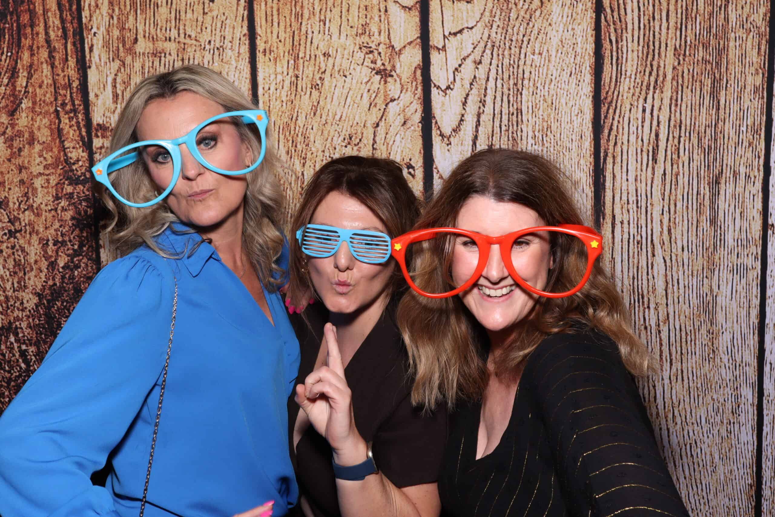 Prom photo booth hire - women posing with oversized novelty glasses