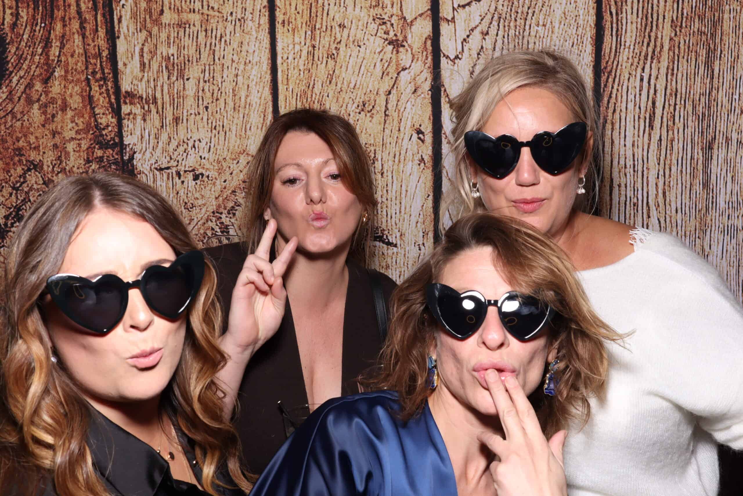 Party photo booth hire - women wearing heart-shaped sunglasses posing together