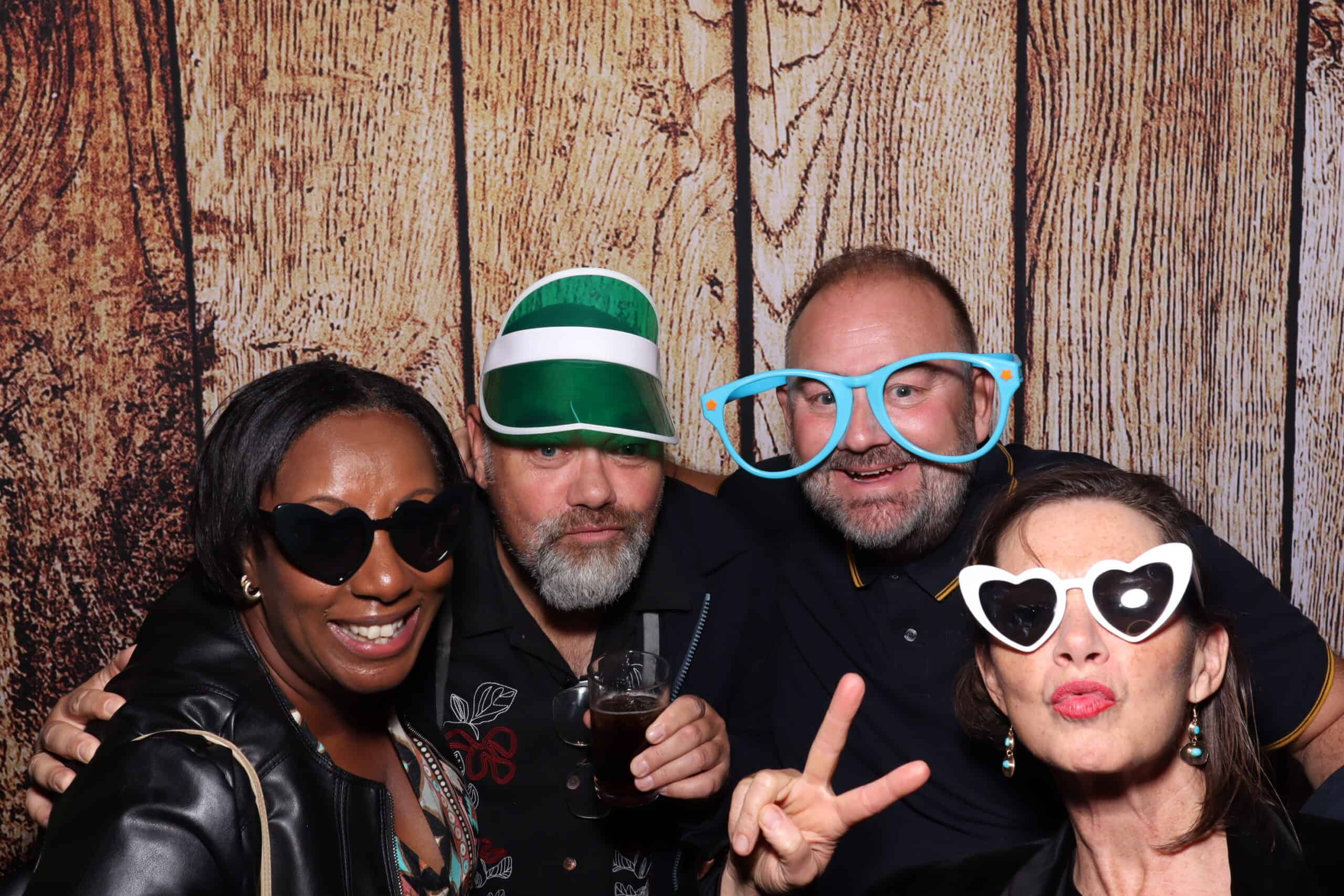 Party guests celebrating with heart-shaped sunglasses at photo booth hire