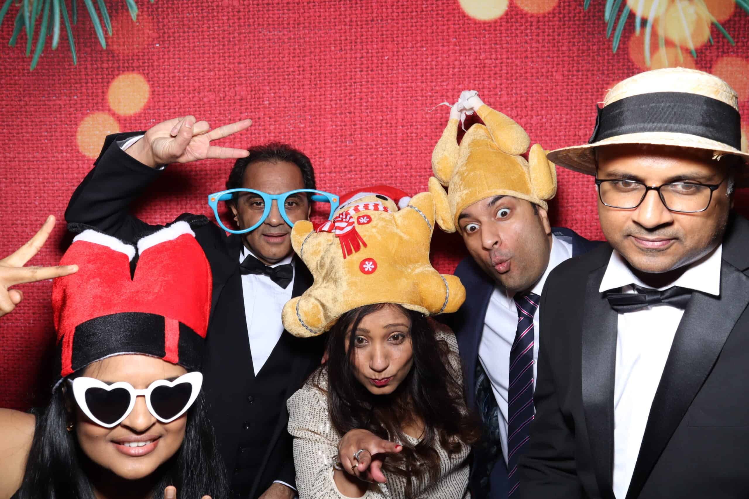 Guests celebrating at a Christmas photo booth with festive props