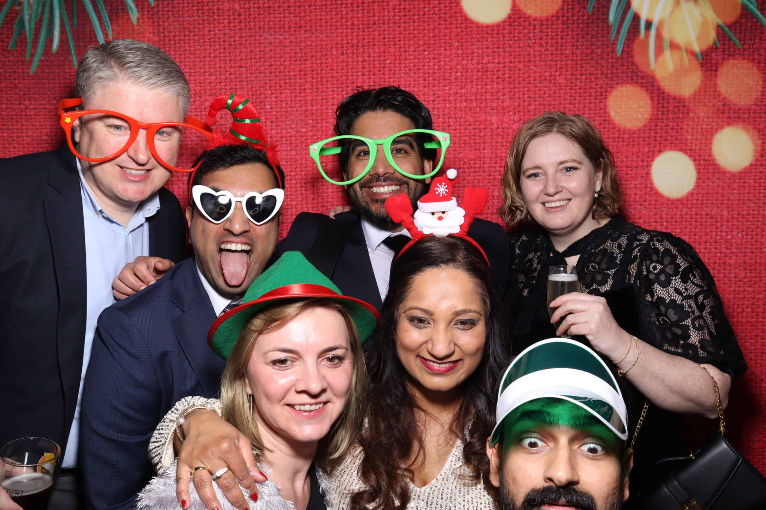 Christmas party photo booth hire with colleagues wearing festive props