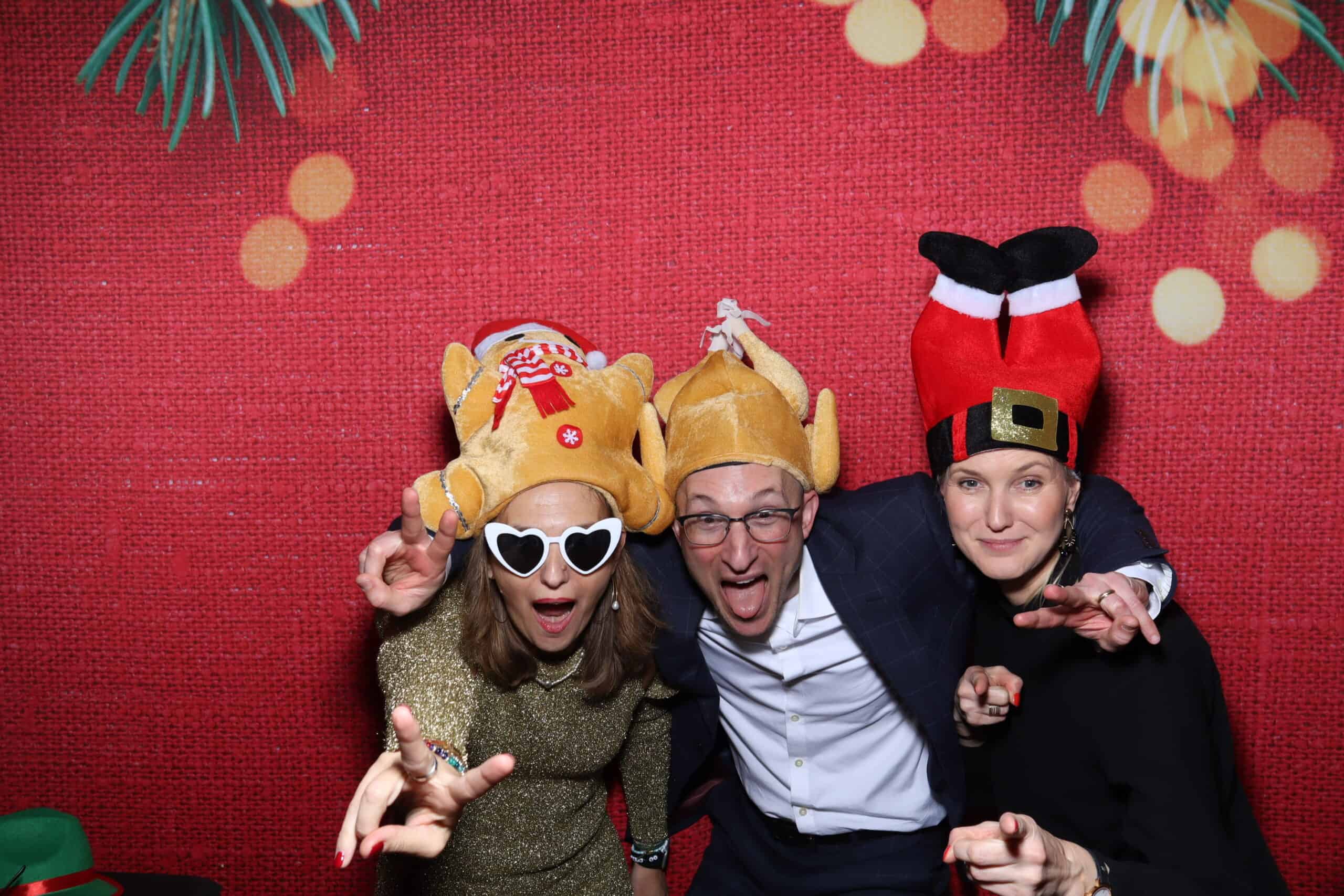 Christmas photo booth hire - guests with Santa hats and festive props